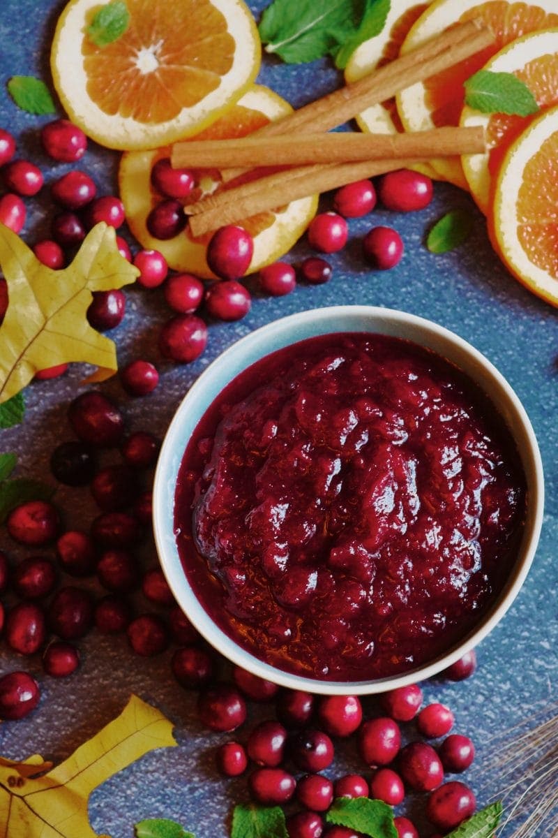 fresh cranberry sauce on blue background with autumn decor