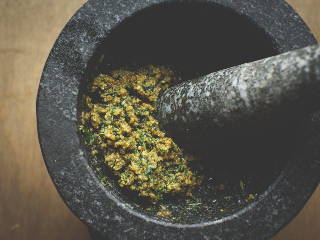 Spring Pesto Recipe of Wild Ramps, Garlic Mustard, & Basil made in mortar with pestle