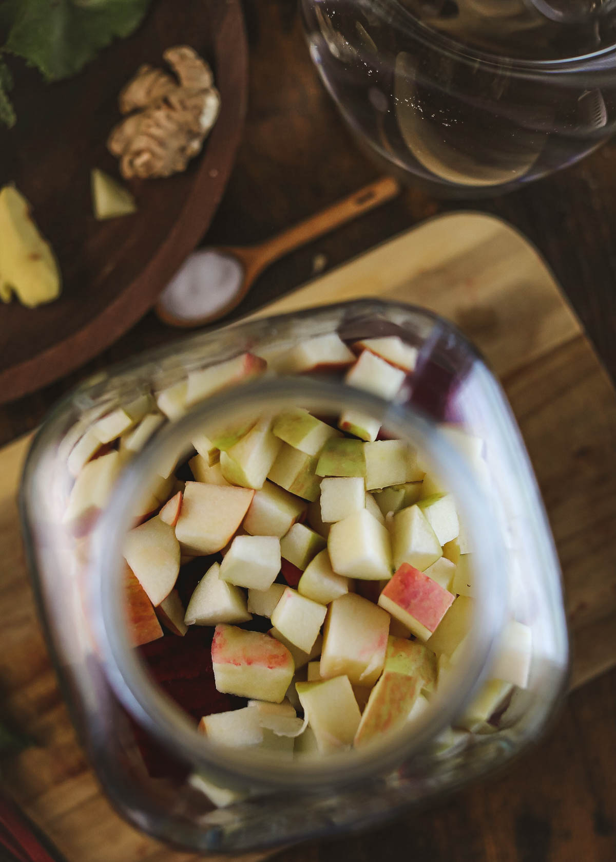 Chopped apples being added to the jar of chopped beets.