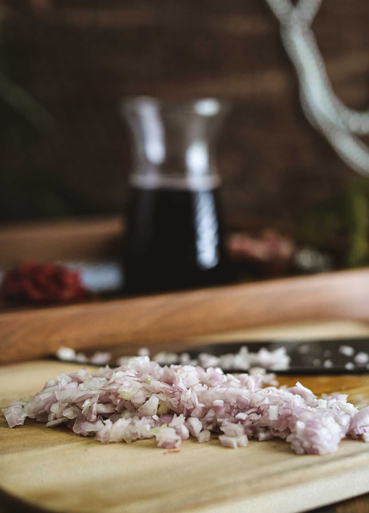 A wooden cutting board with diced onions.