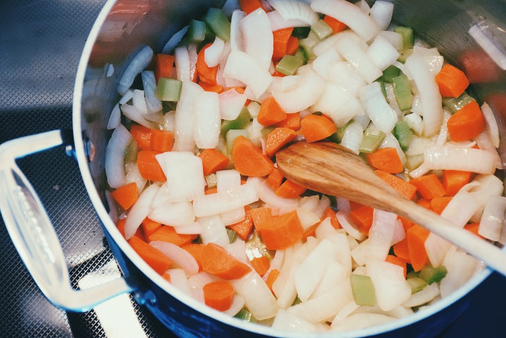 Chopped aromatics in a large steel pot: carrots, celery, onion.