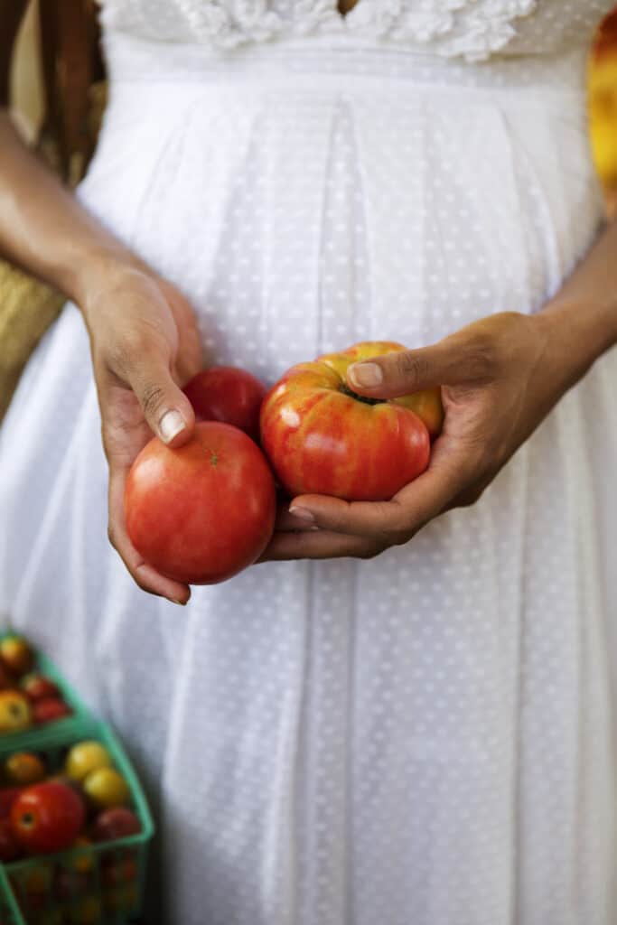 Midsection Of Woman Holding Fresh Tomatoes At Market