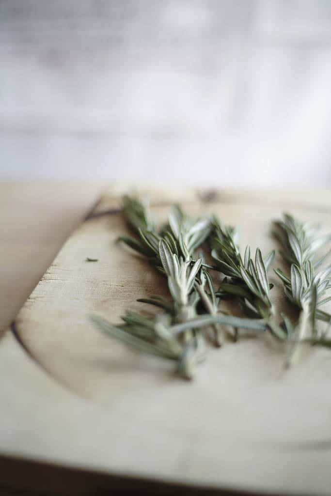 a bunch of rosemary on a wood cutting board