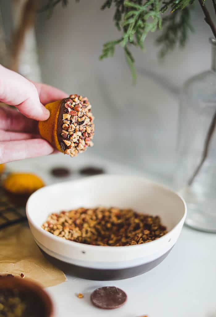 muffin being dipped into crushed nuts.