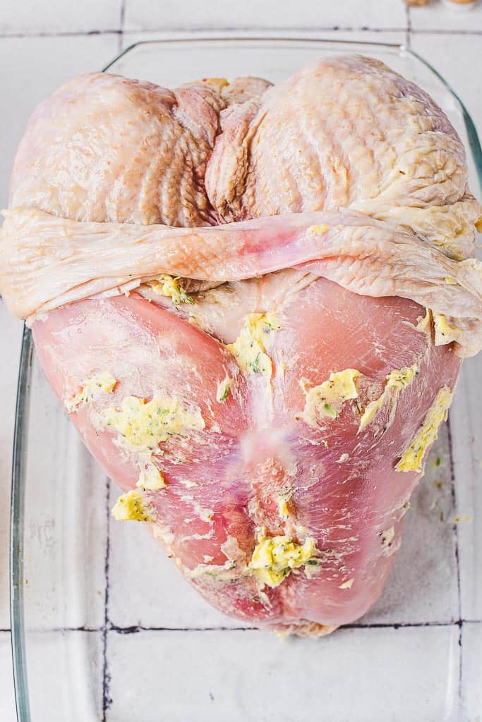 the raw crown roast breast with the skin pulled back and rubbed with the butter mixture