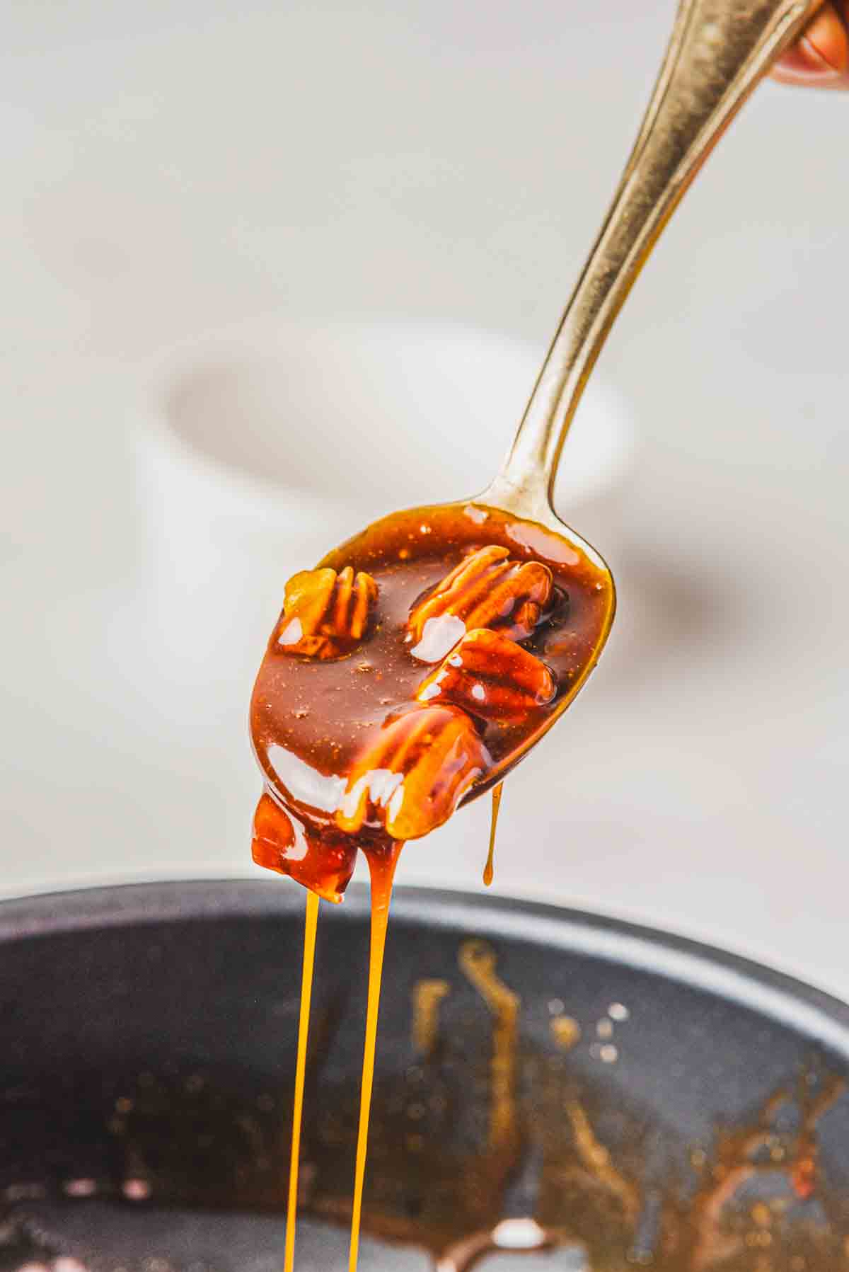 A spoon full of finished caramel pecan sauce for the burnt Basque cheesecake.