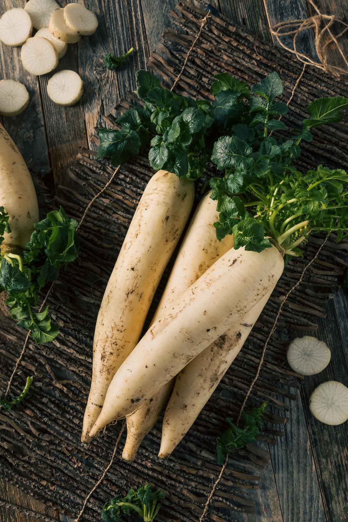 A pile of four thick, white daikon radish that can be used as a cover crop.