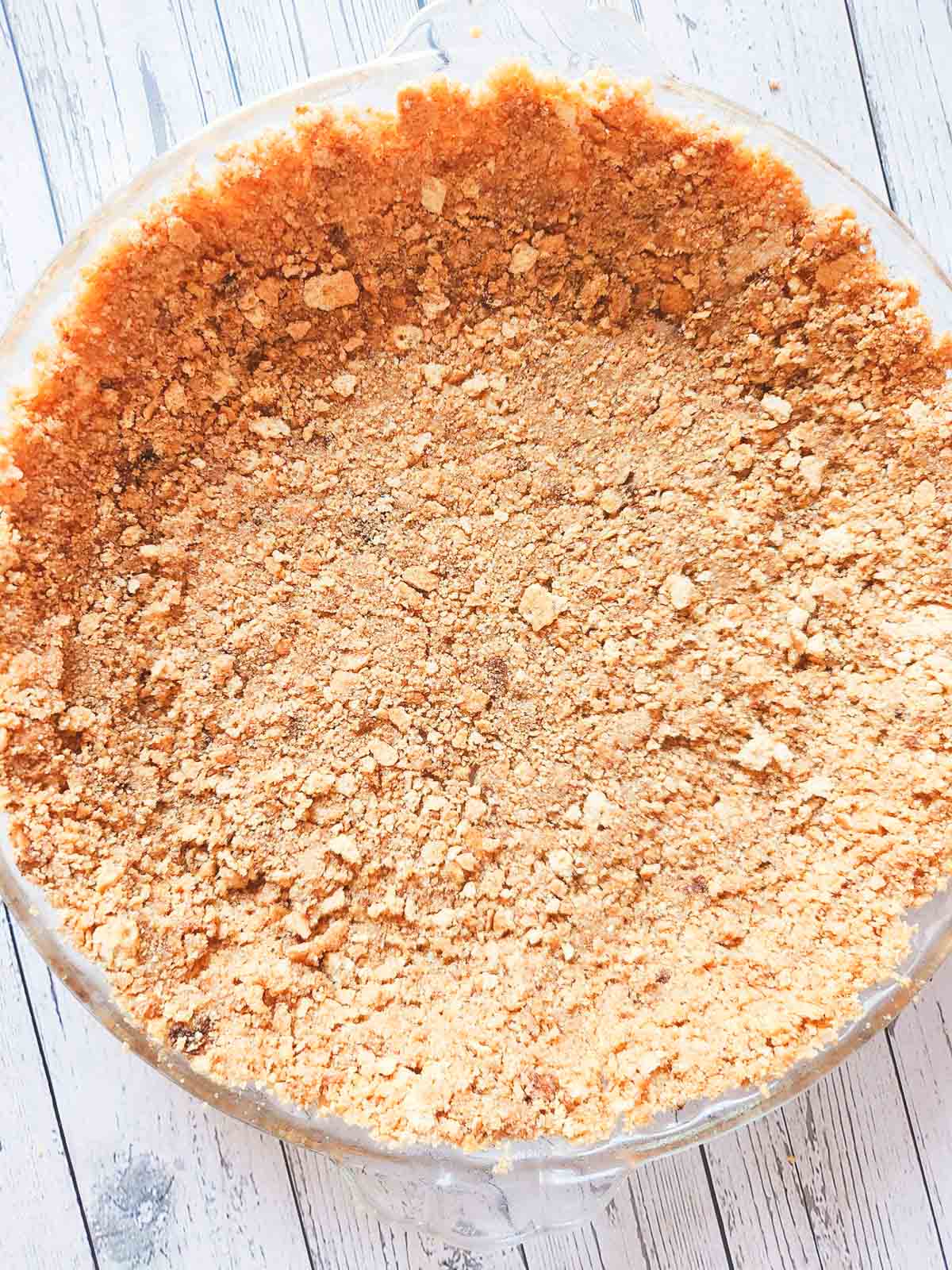 The graham cracker crust no-bake cheesecake ingredients pressed firmly into the pie shell.