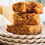 Three blondies stacked on top of white plates.