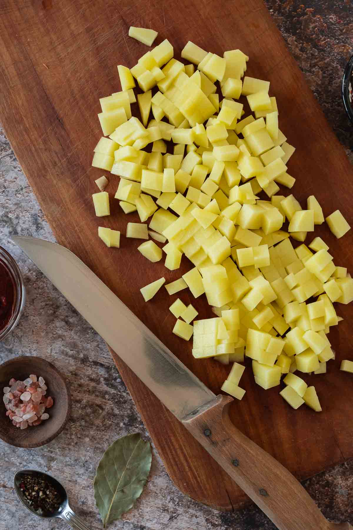 Diced potatoes on wooden board.