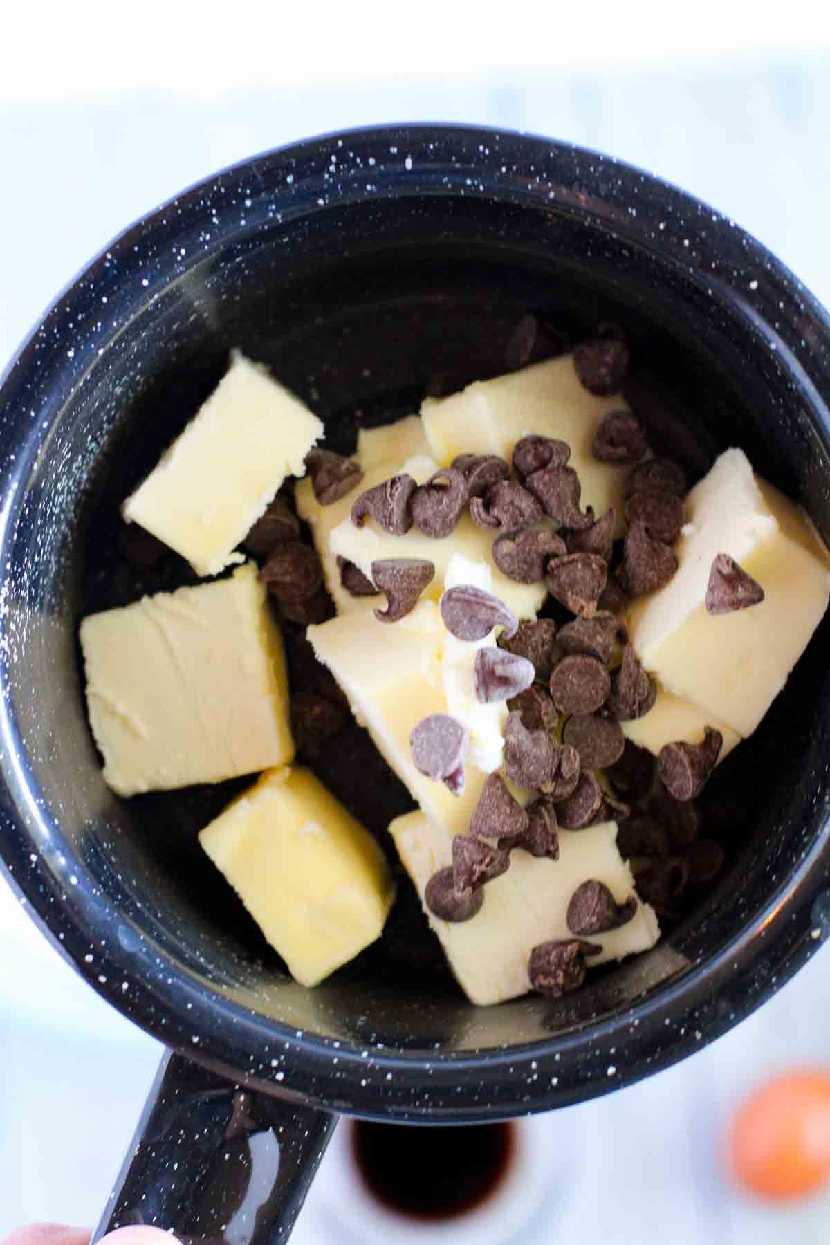 Cut up butter and chocolate chips in a dark enamelled pot.