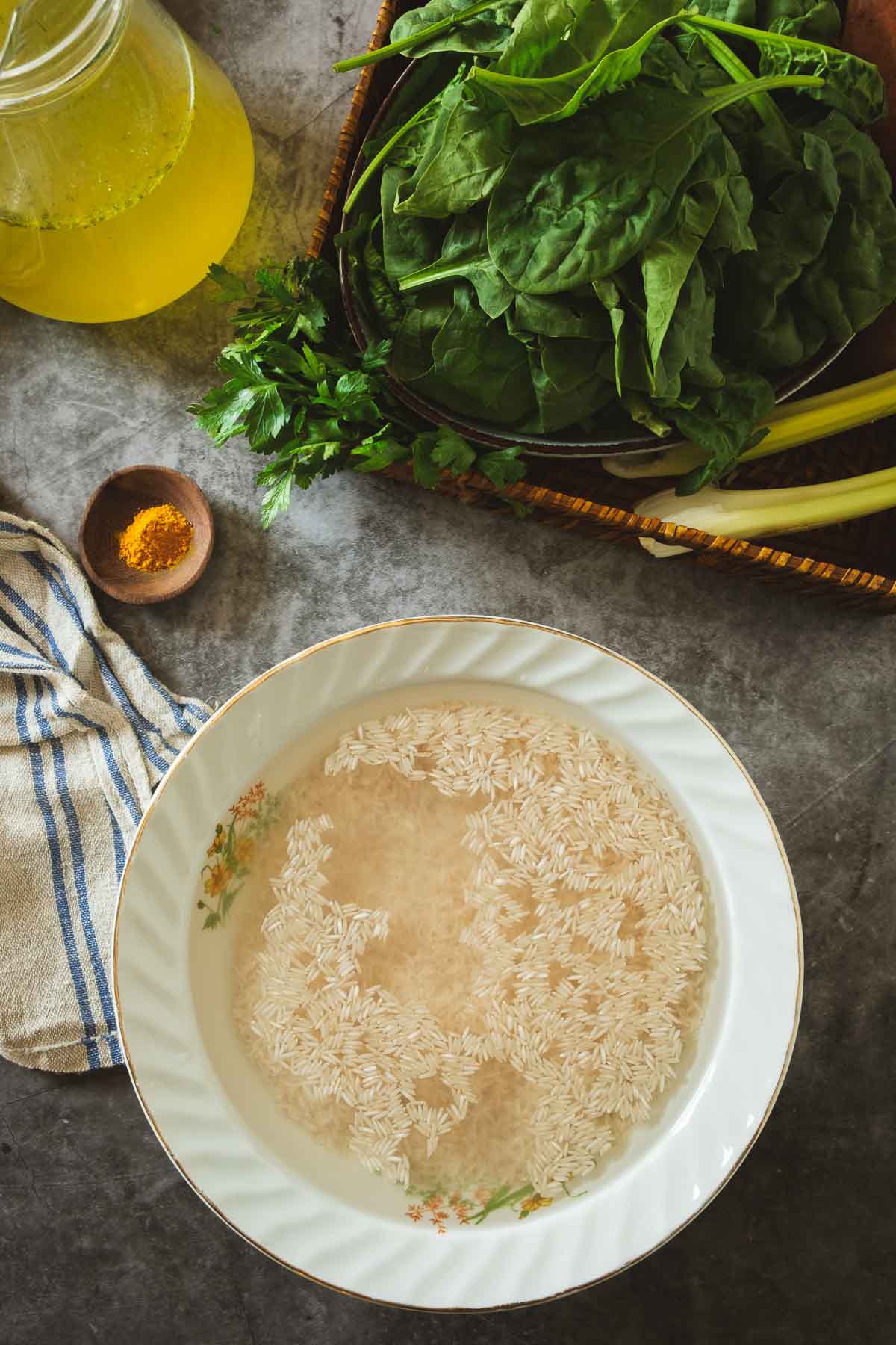 Basmati rice soaking in a bowl next to the other soup ingredients.