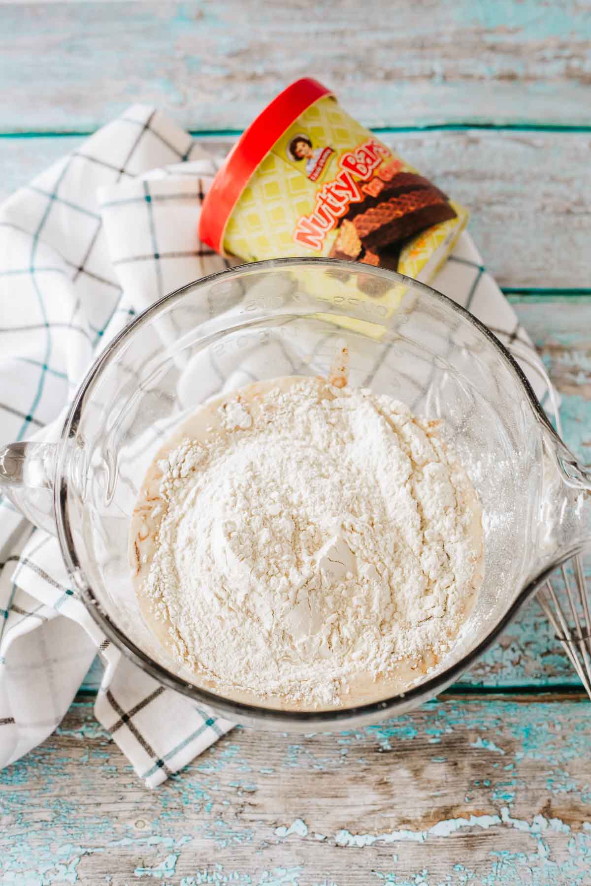 All-purpose flour and melted ice cream in a glass mixing bowl.