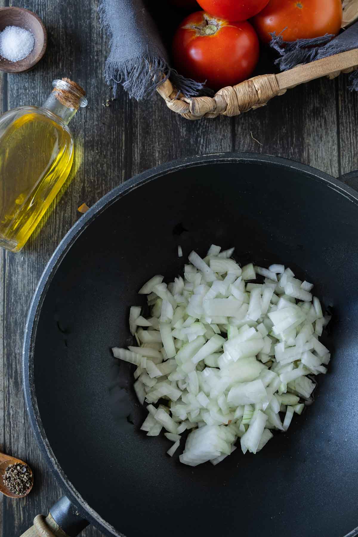 Diced onions inside a dark pan.