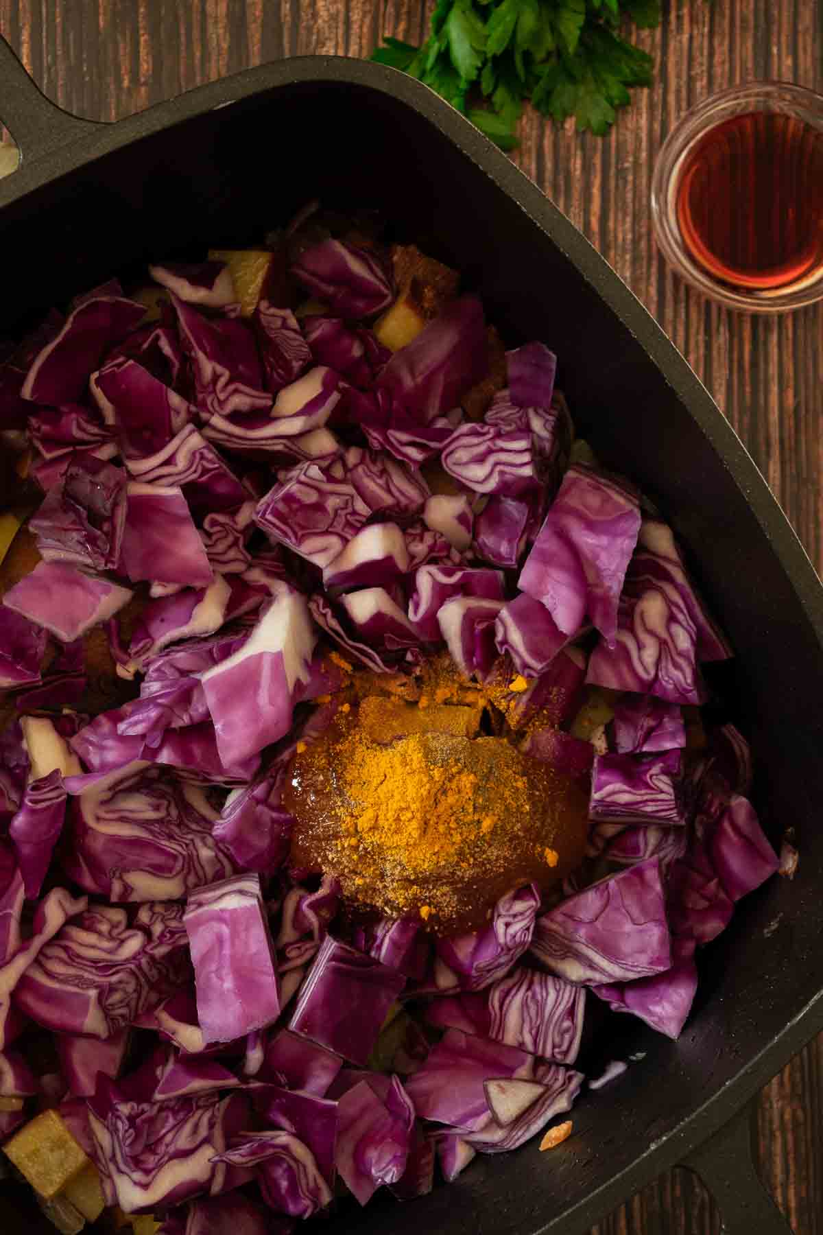 Chopped red cabbage added to the pot with spices.