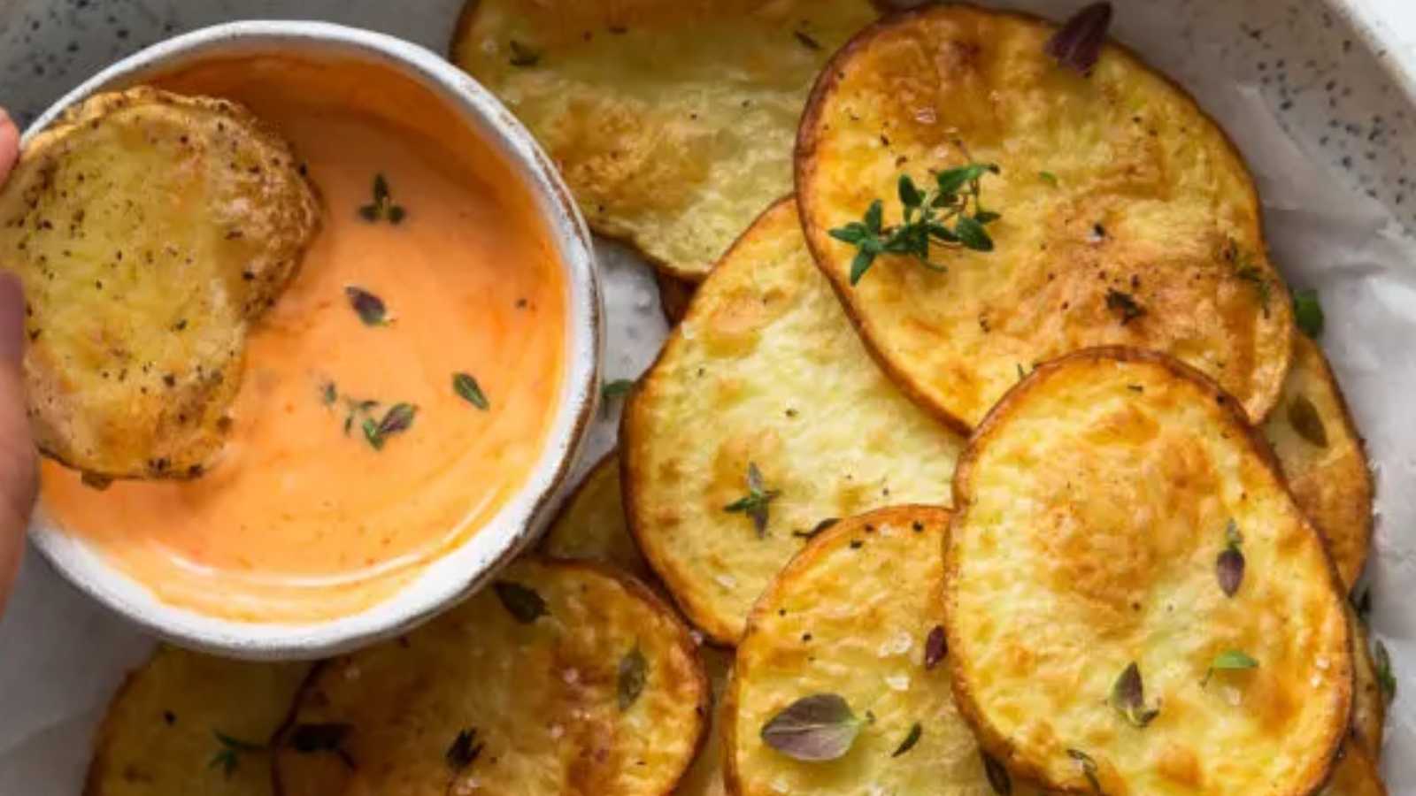 Potato slices with sauce in a bowl.