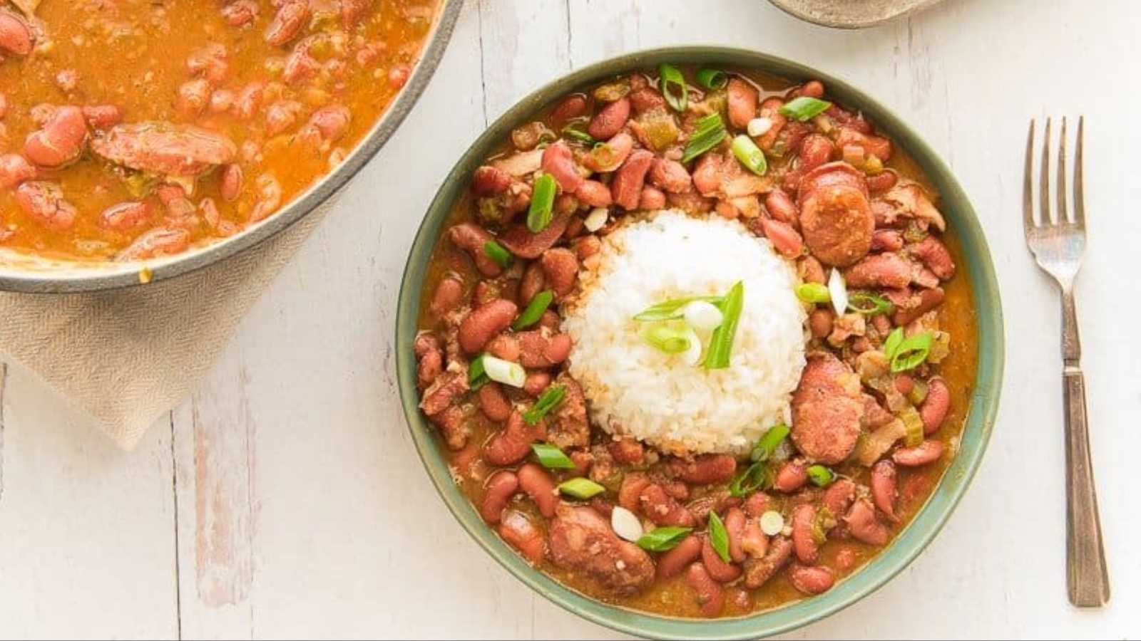 Red beans and smoked meats with rice toppings in a bowl.