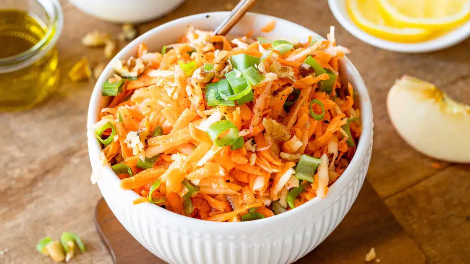 A mixed apple and carrot salad in a bowl.