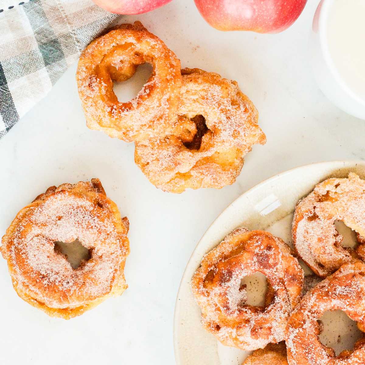 A plate of apple rings dusted with cinnamon sugar on a table.