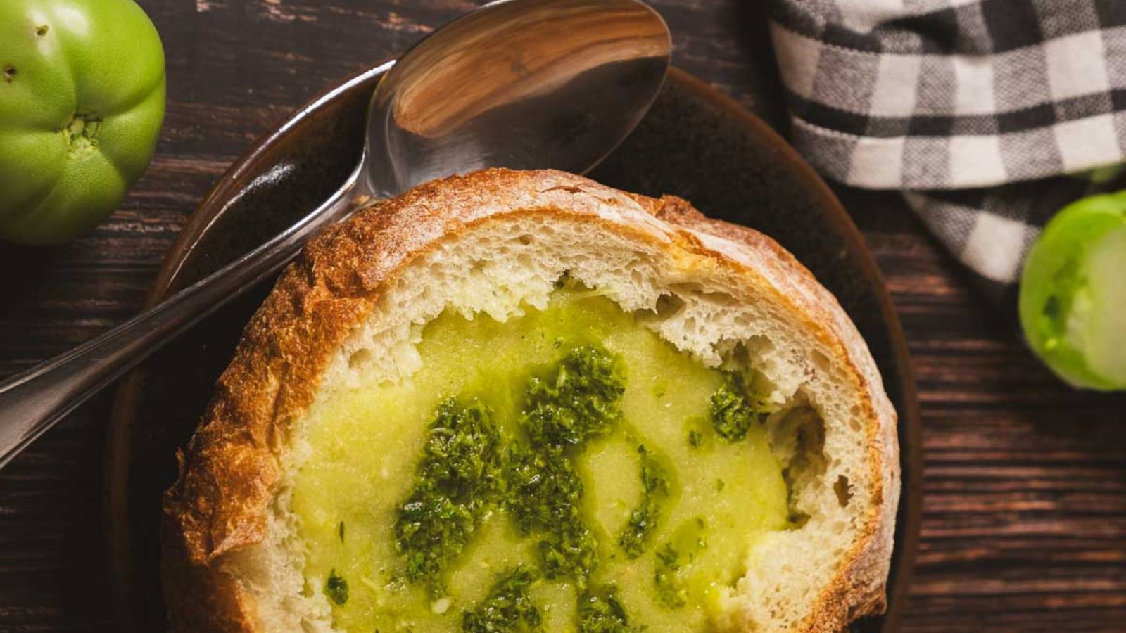 Green tomato soup in bread bowl topped with pesto.