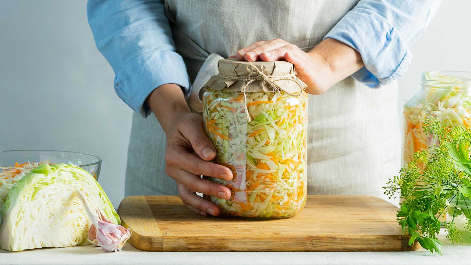 A jar of sauerkraut held by hands.