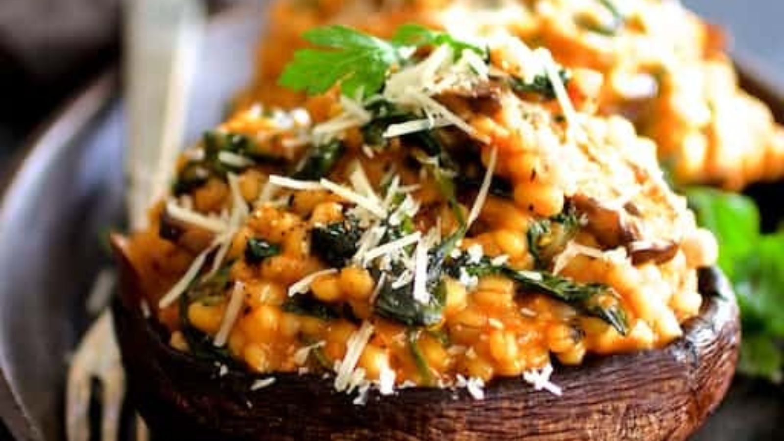 A plate of stuffed mushrooms with barley, cheese, and spinach.