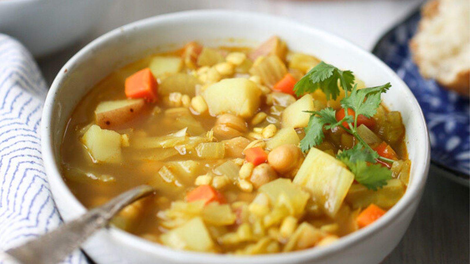 A bowl of vegetable barley soup flavored with curry powder.