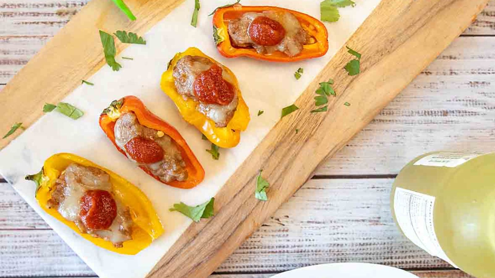 Italian Sausage Stuffed Mini Peppers with mozzarella and pizza sauce on the board.