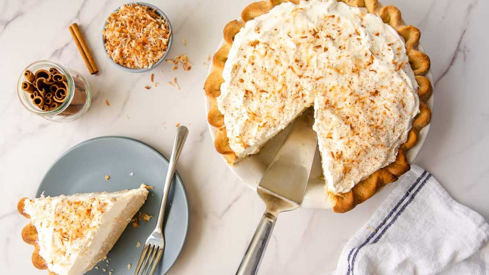 A plate of coconut, cinnamon, and rum custard, topped with fluffy whipped cream.