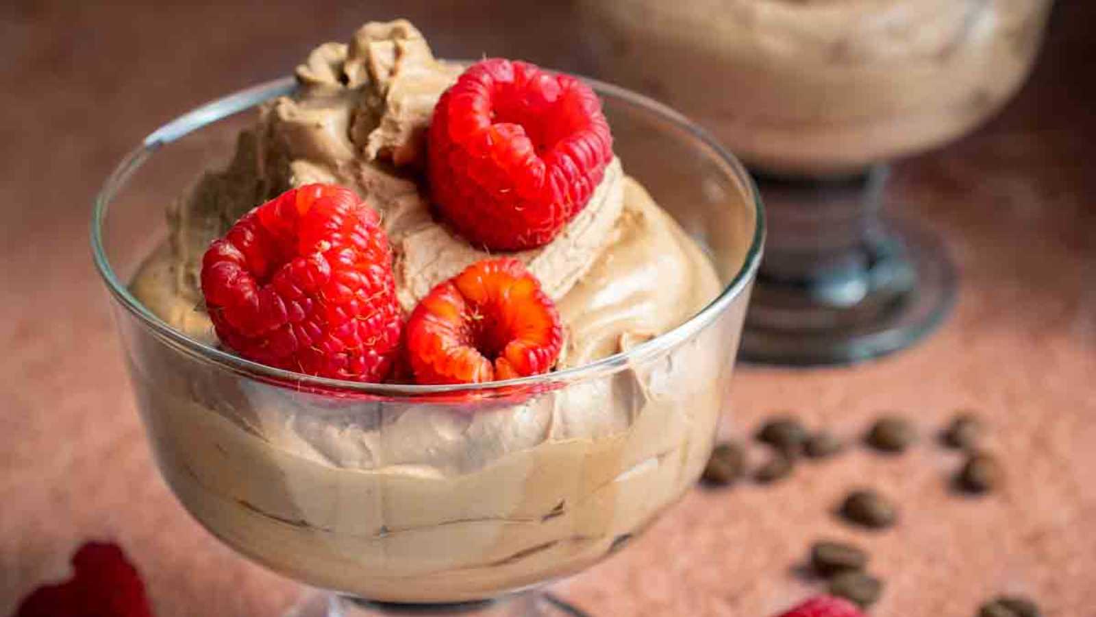 A glass of eggless coffee mousse with strawberry topping.