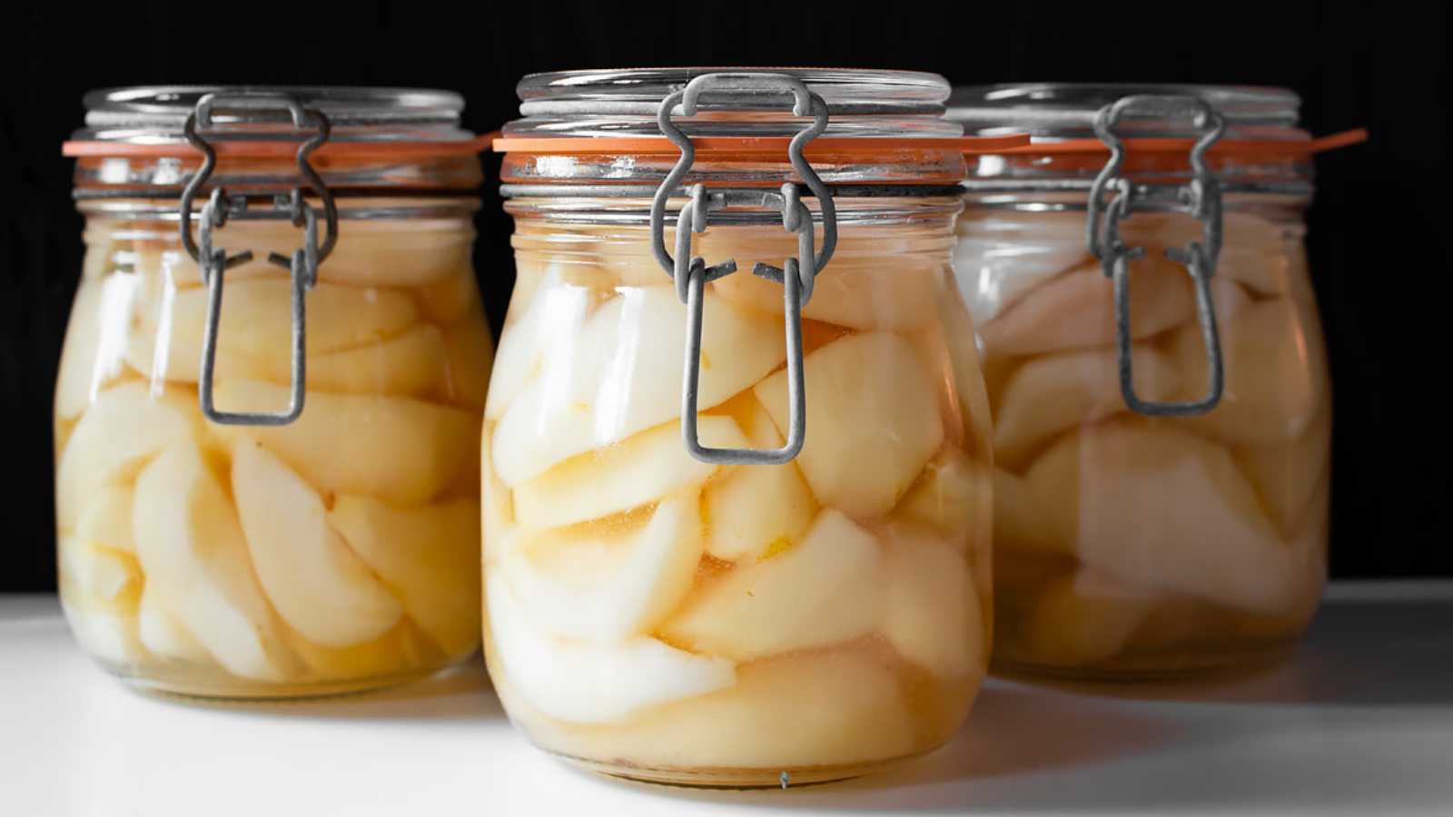 Three jars of pears in syrup.