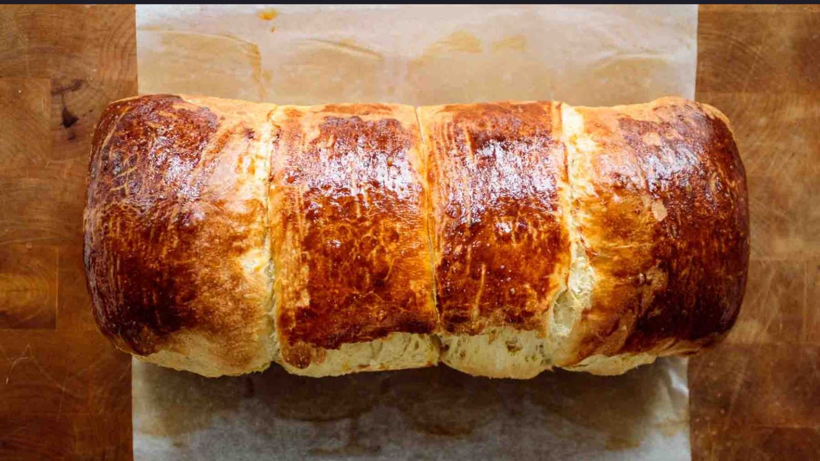 A loaf of golden brown sourdough brioche bread.