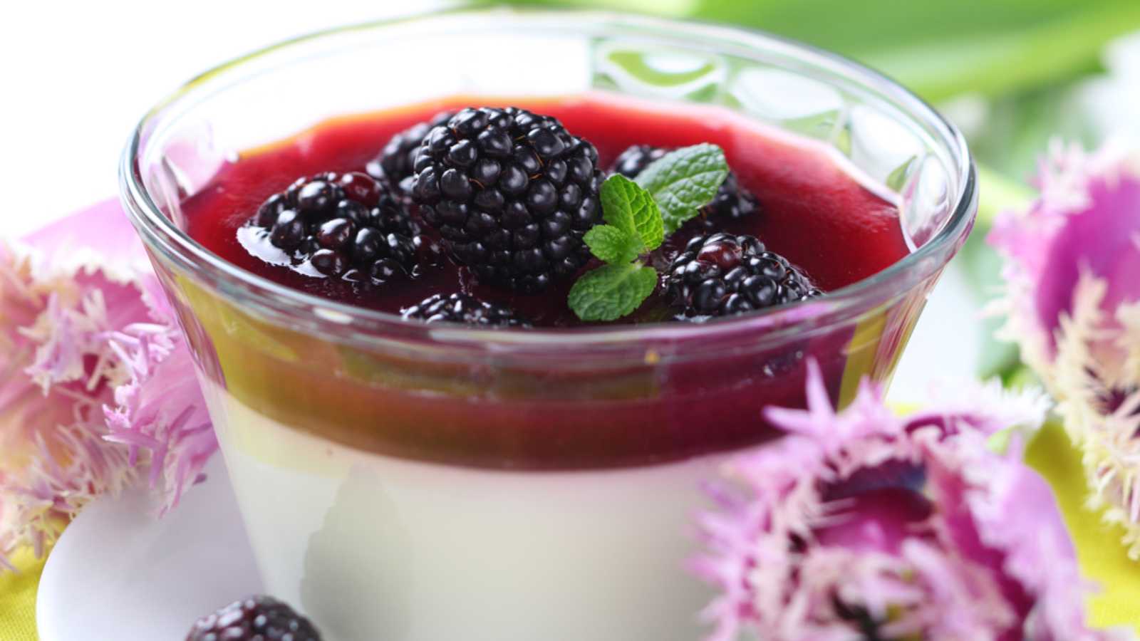 A glass of fresh blackberries and mint atop a delectable dessert.
