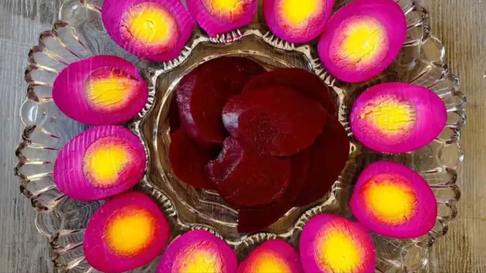 Vibrant red beet eggs nestled around a round plate.