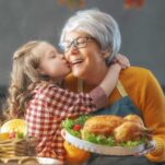 Loving family bonds: A tender moment between a grandmother and granddaughter, as the grandma lovingly kisses her cheek.