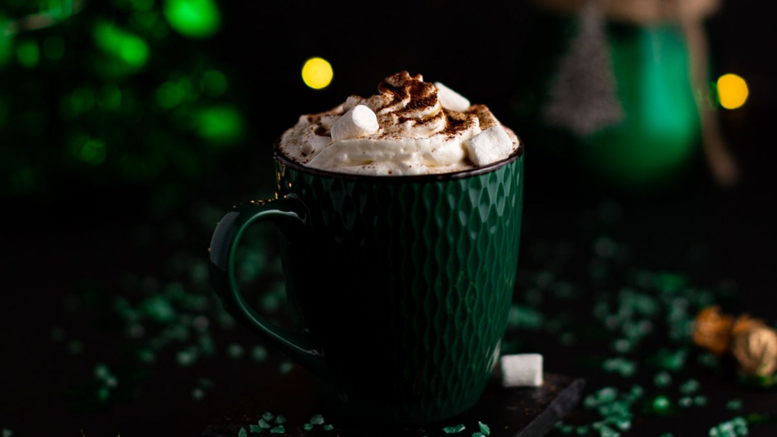 A mug of hot chocolate, topped with whipped cream and marshmallow.
