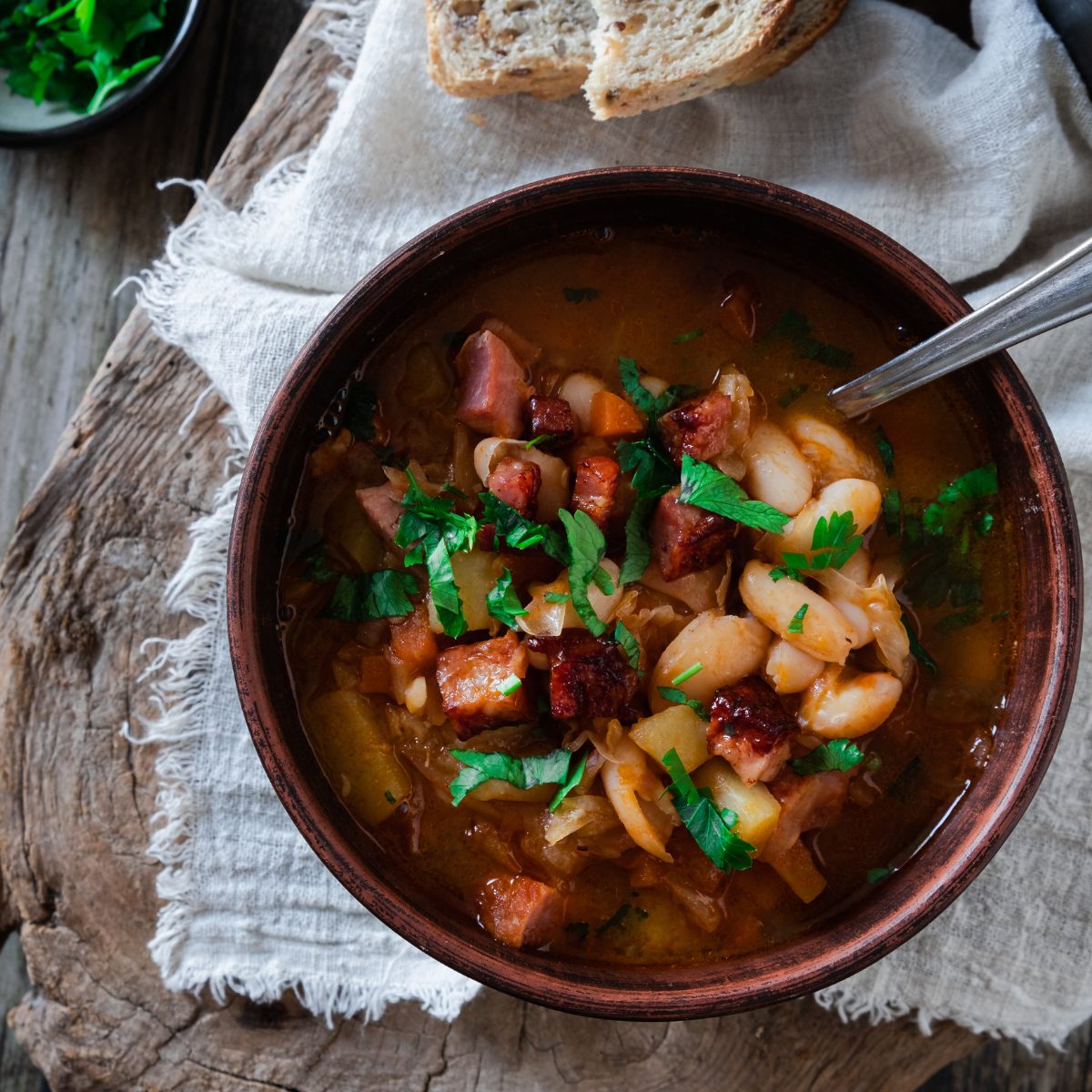 A bowl of Istrian jota soup or stew full of ham, beans, sauerkraut, bacon, and other vegetables.