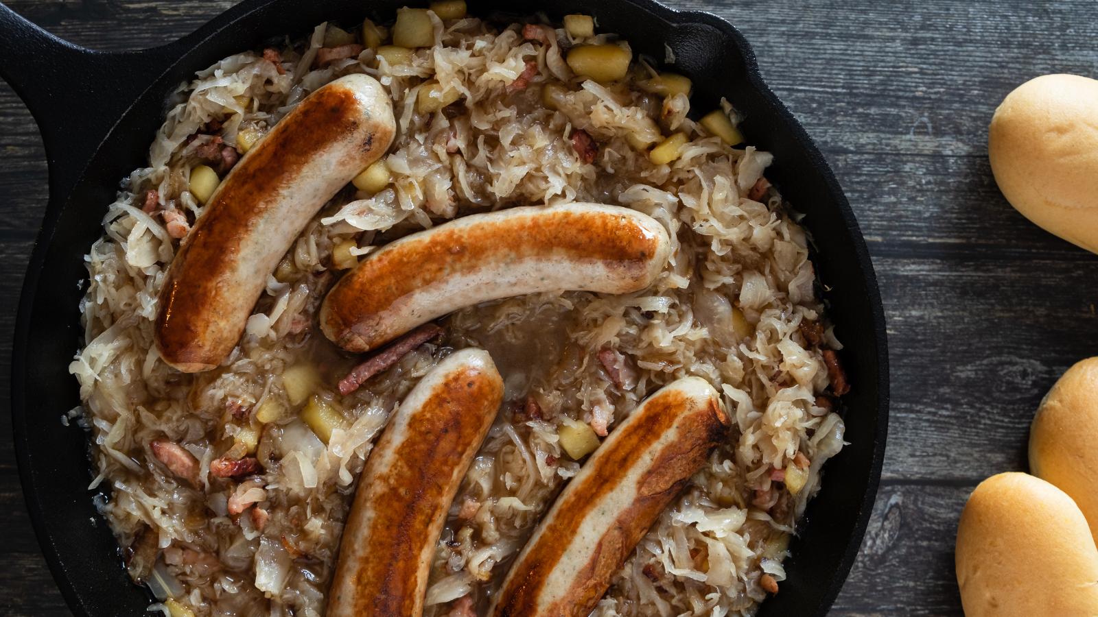 The browned bratwurst sausages in the sauerkraut ready to braise and finish cooking.