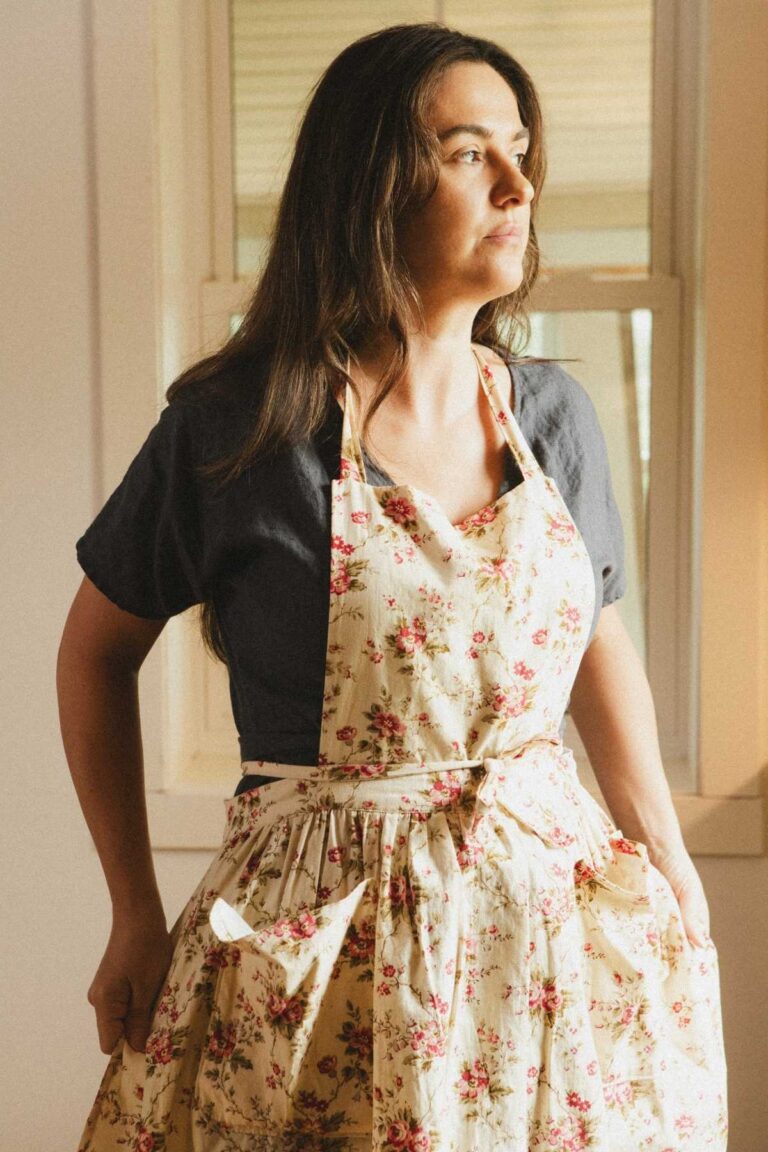 Me standing in my kitchen wearing a floral apron.