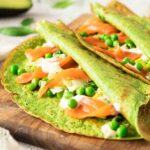 Smoked salmon and avocado salad with creamy dressing served inside spinach crepes.