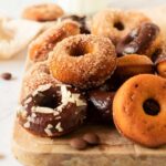 The finished baked pumpkin donuts with various toppings and glazes.