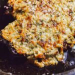 Parmesan crusted ribeye steak in a cast iron skillet.-steak