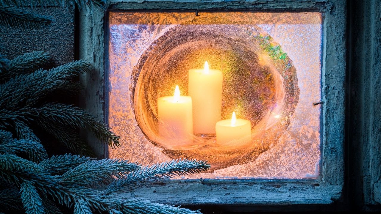Christmas candles lit at window.