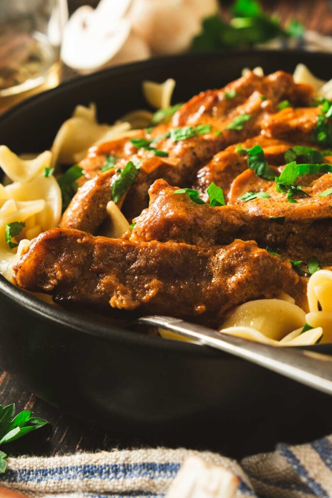 Beef Stroganoff were served over egg noodles and garnished with parsley.