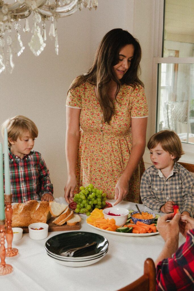 A woman serves her two young boys lunch.
