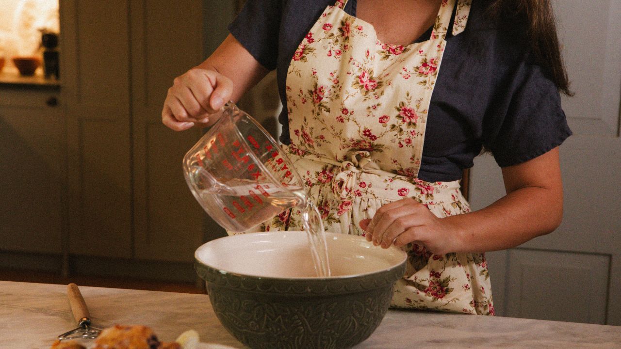 Me preparing sourdough bread wearing an apron in my kitchen.