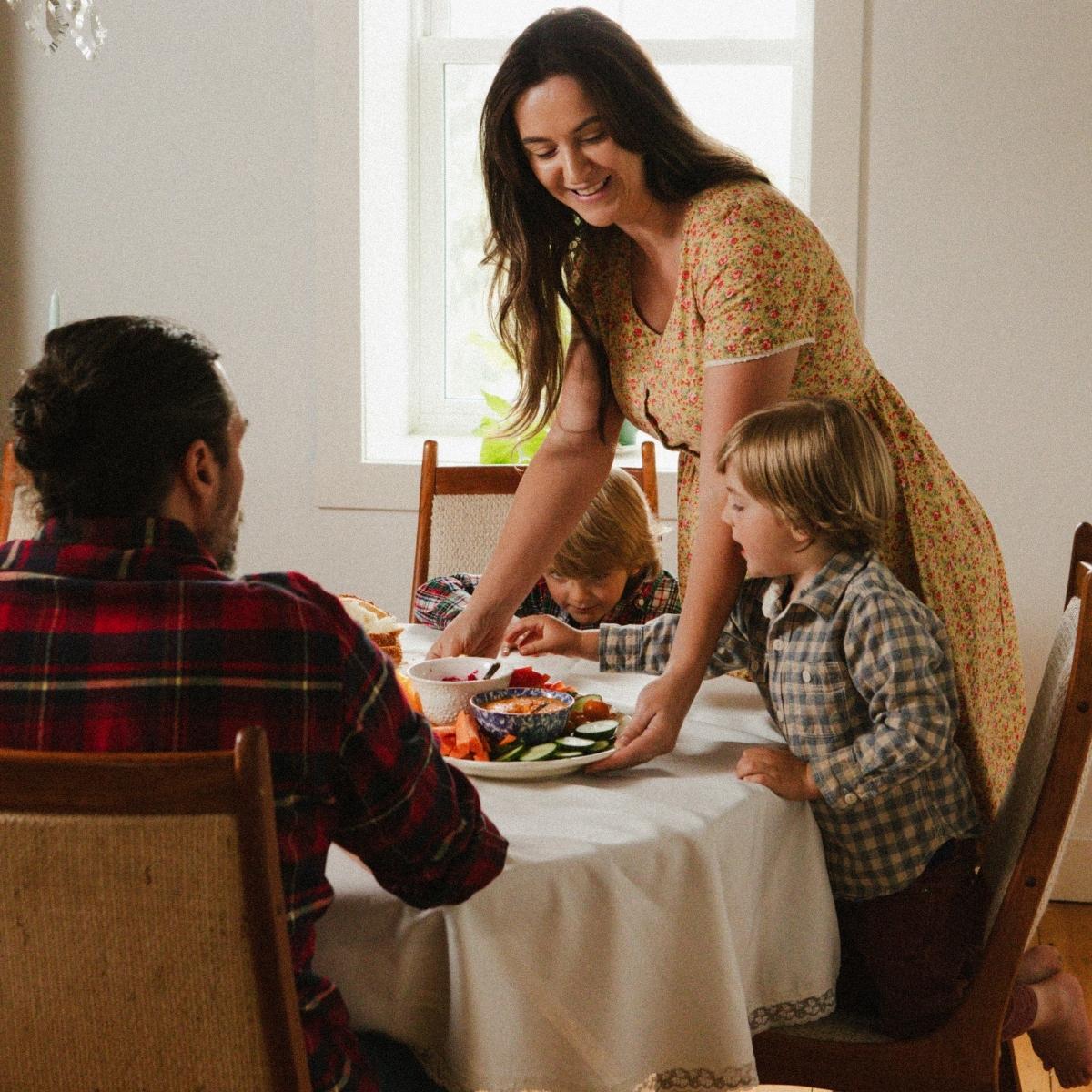 A mother serves her family a meal.