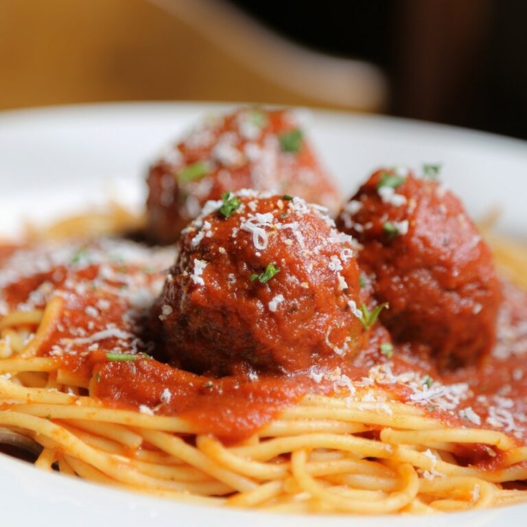 Saucy meatballs in red sauce served on top of spaghetti.