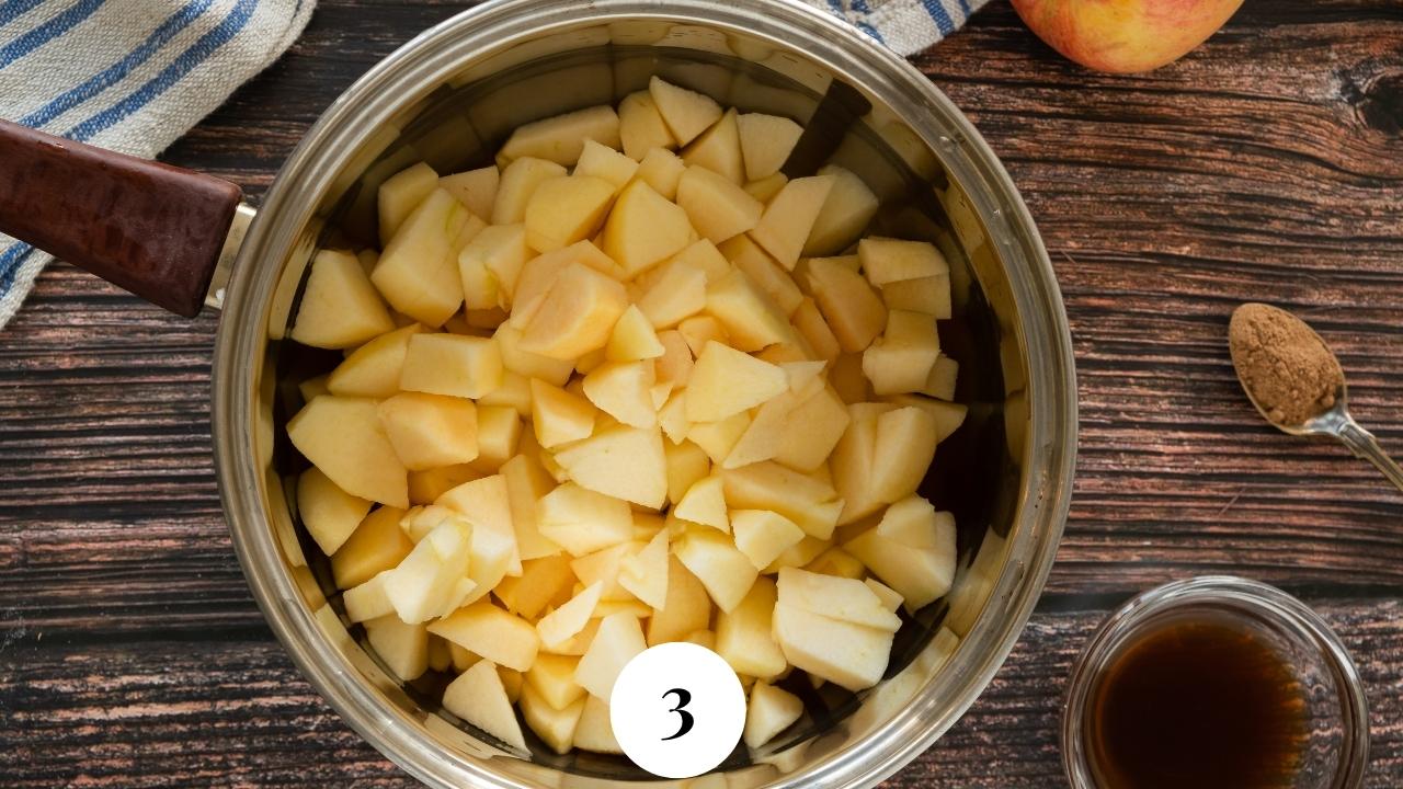 Chunks of raw, peeled apples in a pot.