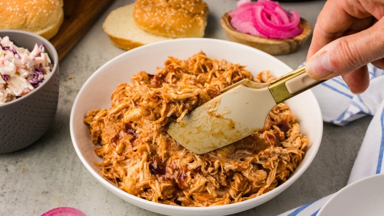 A bowl of shredded BBQ chicken smothered in homemade BBQ sauce.